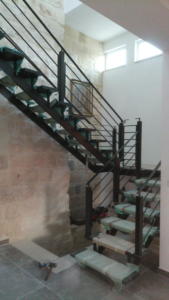 Modern Wrought Iron stair case and hand railing featuring thick glass steps - General Metal Works Malta
